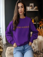 Woman sitting indoors in purple Embroidered Humble Sweatshirt