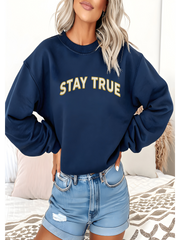 Woman wearing Embroidered Stay True Sweatshirt in navy blue, casual style.