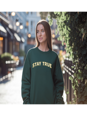 Woman wearing Embroidered Stay True Sweatshirt in forest green, street style.