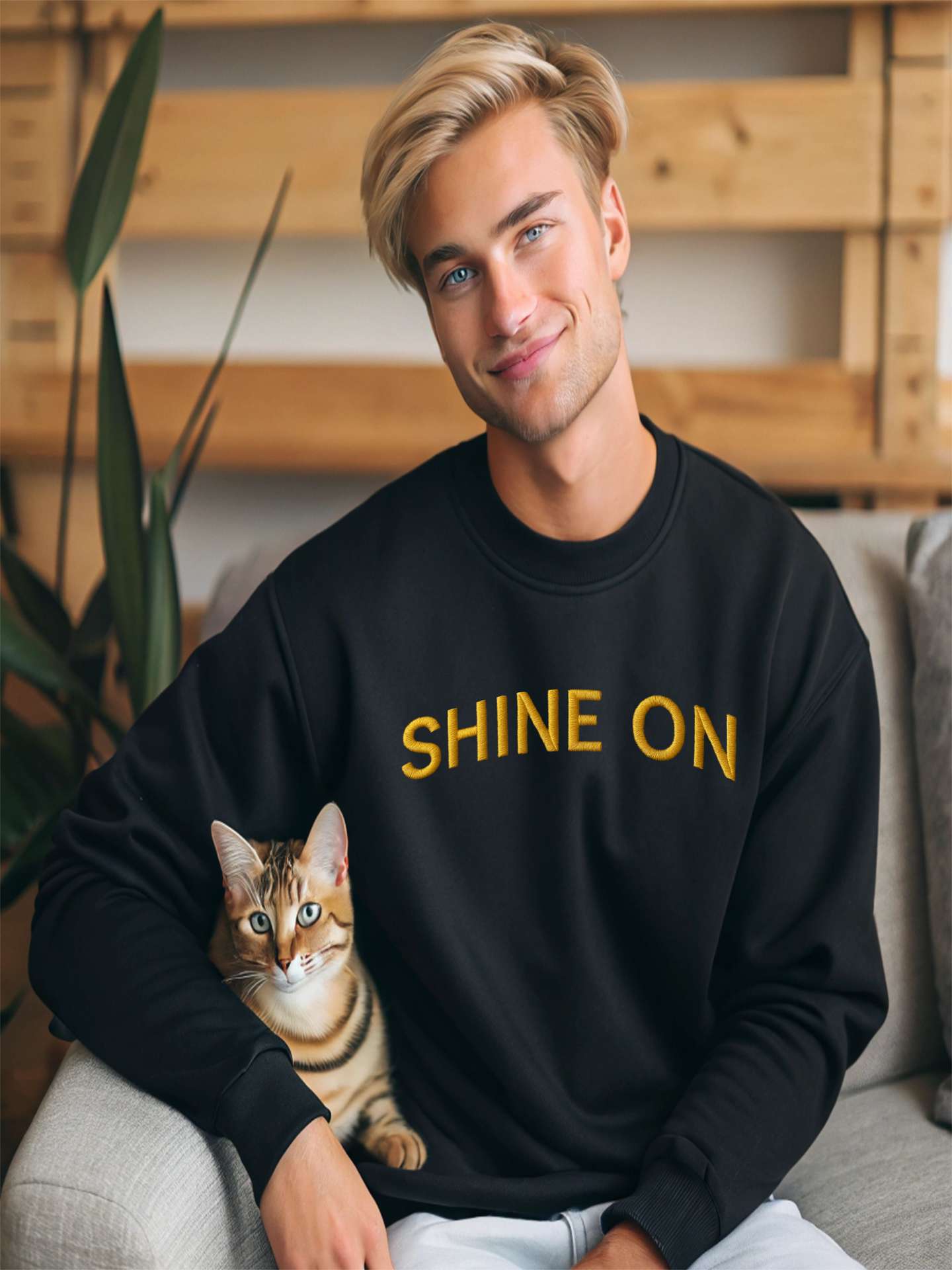 Young man sitting wearing Embroidered Shine On Sweatshirt in black