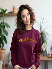 Woman wearing maroon Embroidered Shine On Sweatshirt indoors