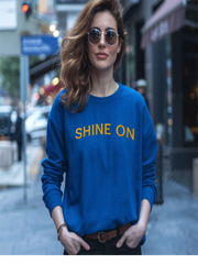 Woman in blue Embroidered Shine On Sweatshirt walking outdoors