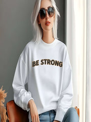 Embroidered Motivational Sweatshirt featuring the text 'BE STRONG', worn by a model in a bright room.