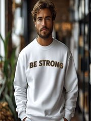 Embroidered Motivational Sweatshirt featuring 'BE STRONG' design on a model in a cozy indoor setting.