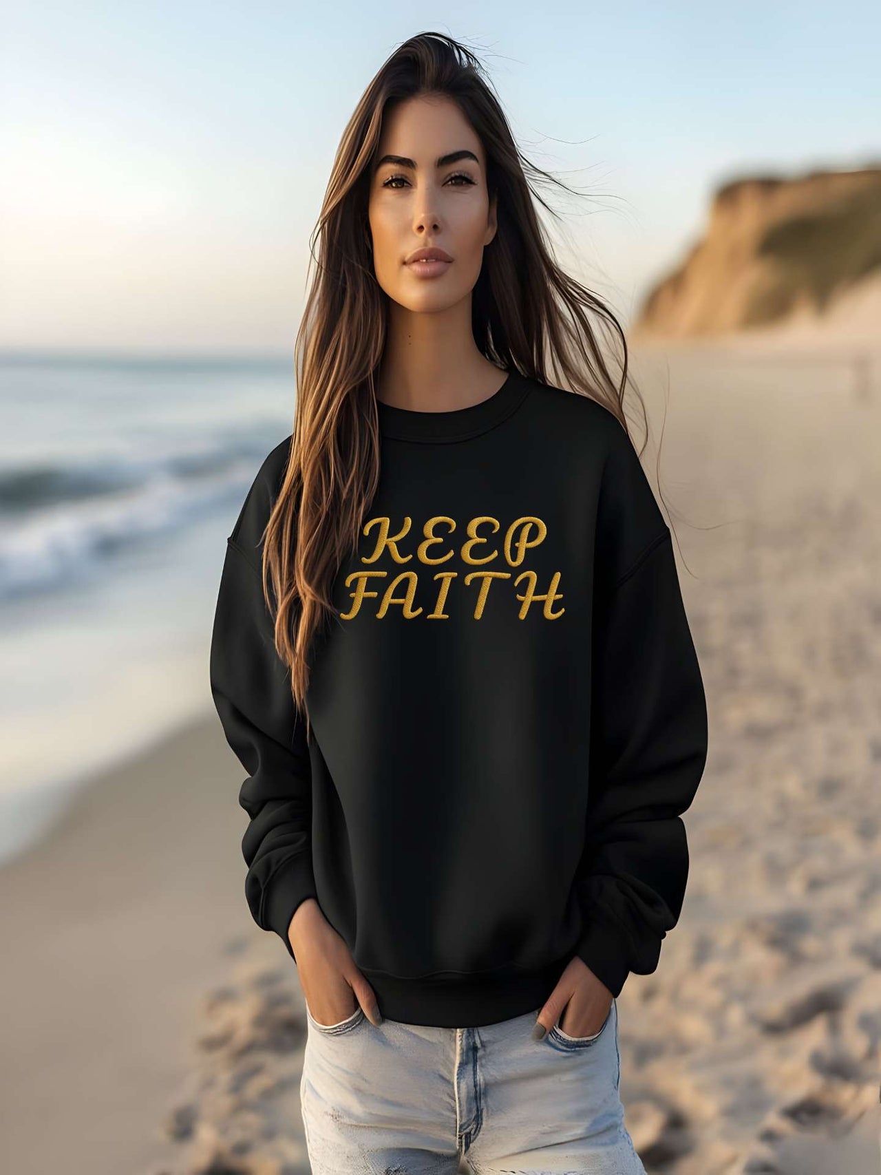 Woman on the beach wearing Embroidered Keep Faith Sweatshirt in black