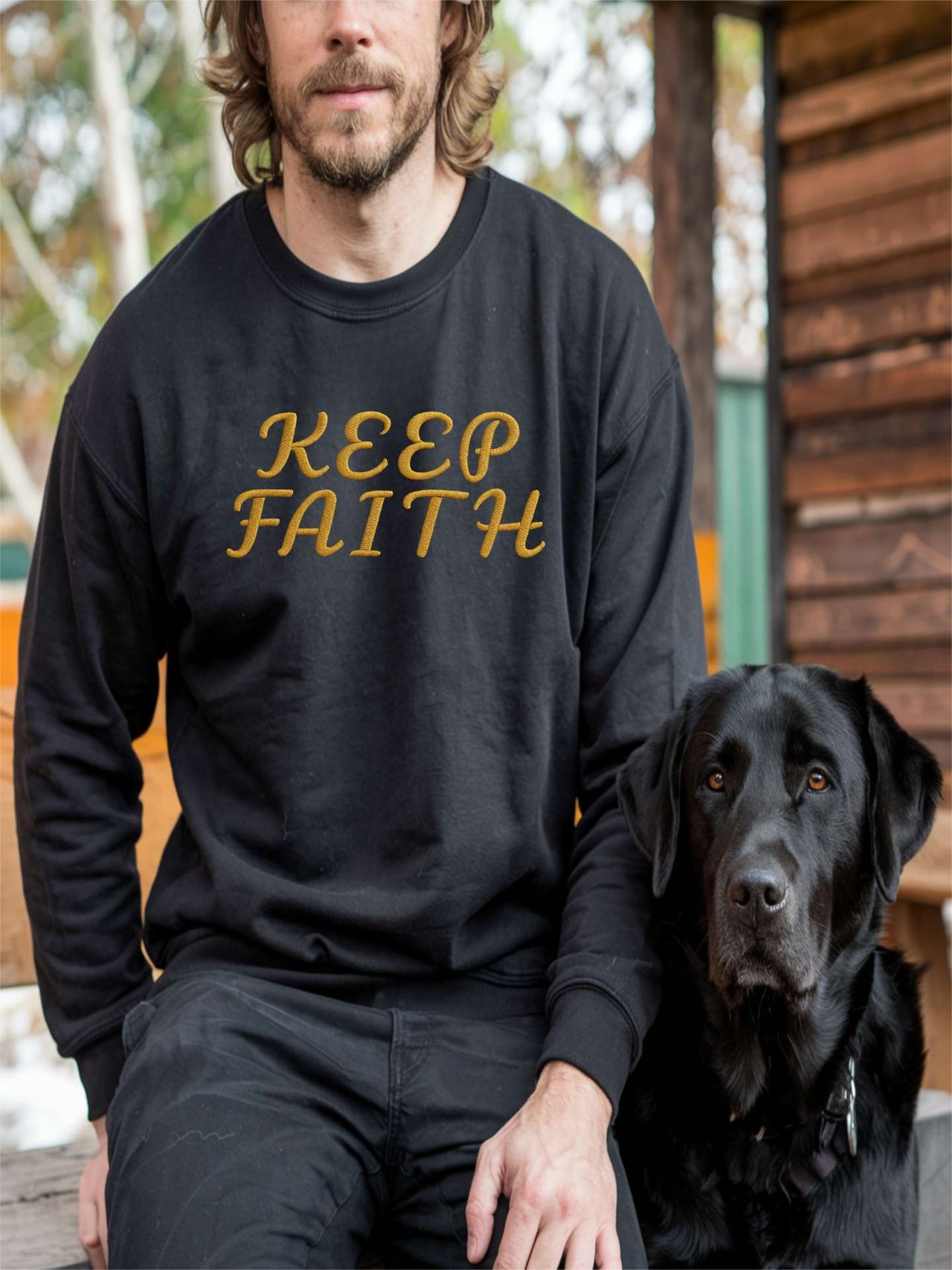 Man with dog wearing Embroidered Keep Faith Sweatshirt in dark heather