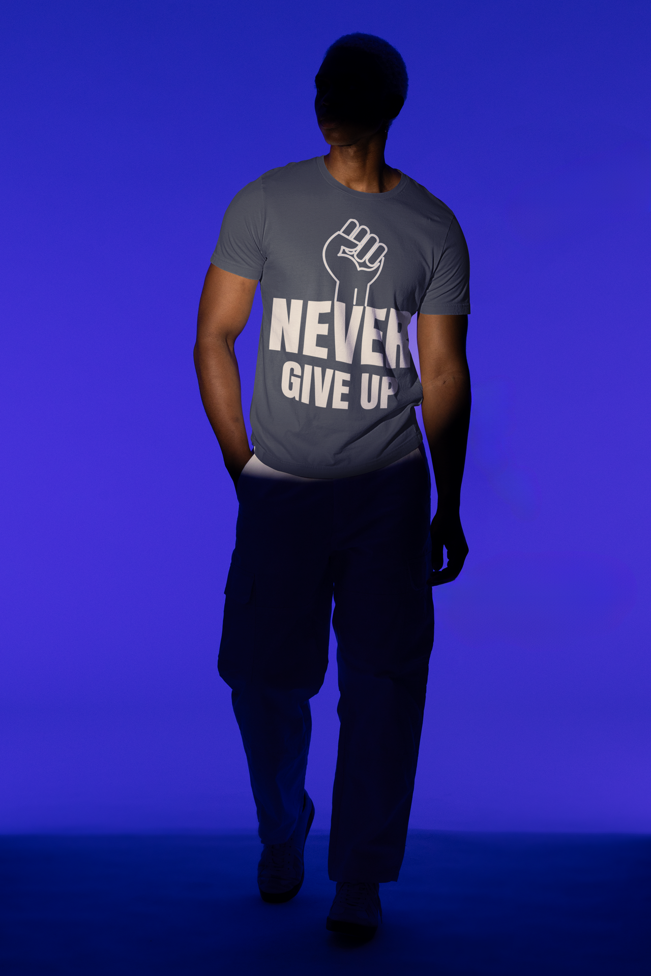 Motivational t-shirt featuring a bold fist graphic and the phrase 'NEVER GIVE UP' on a model against a blue background.