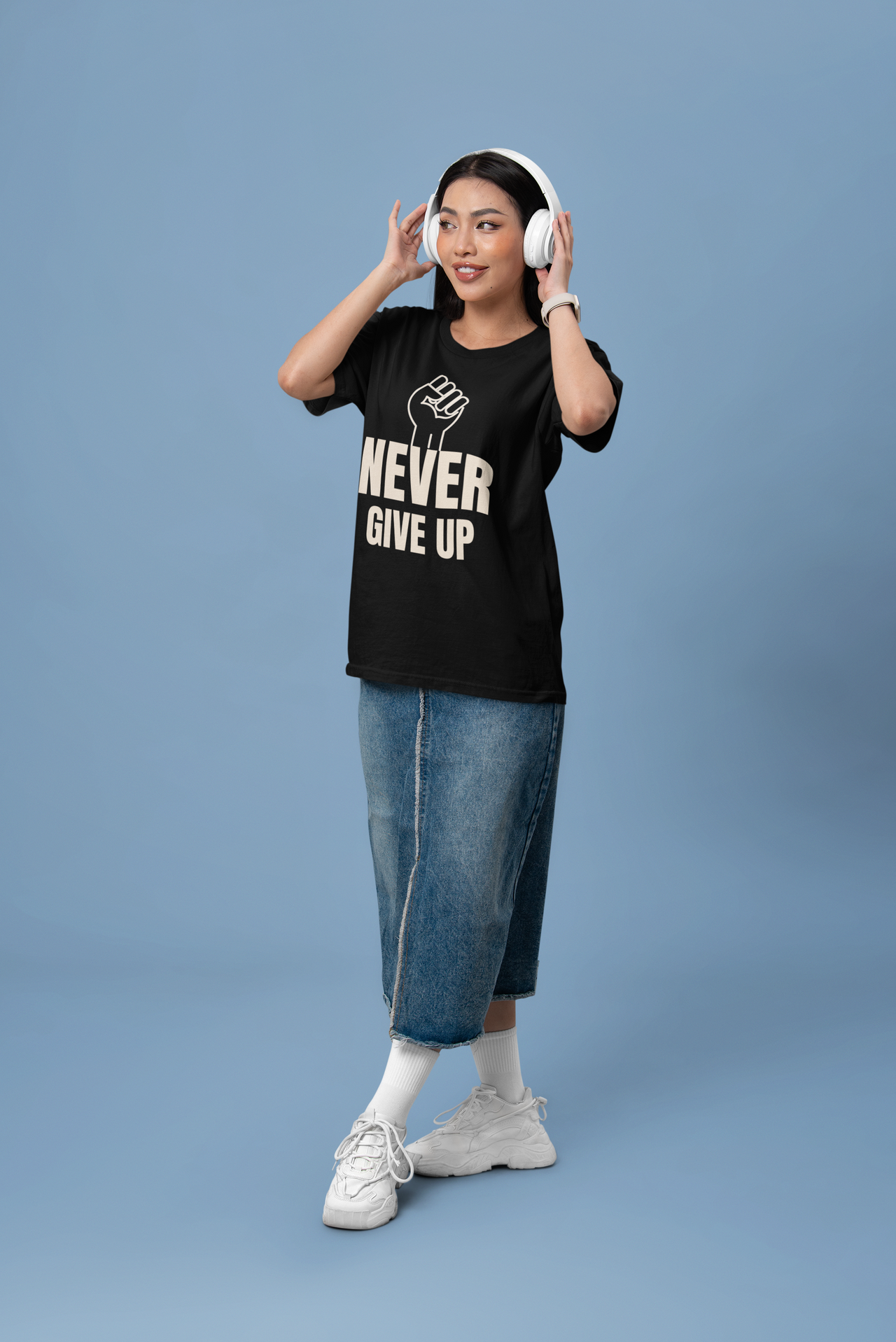 Woman wearing a motivational t-shirt that says 'NEVER GIVE UP' with a fist graphic, showcasing resilience.