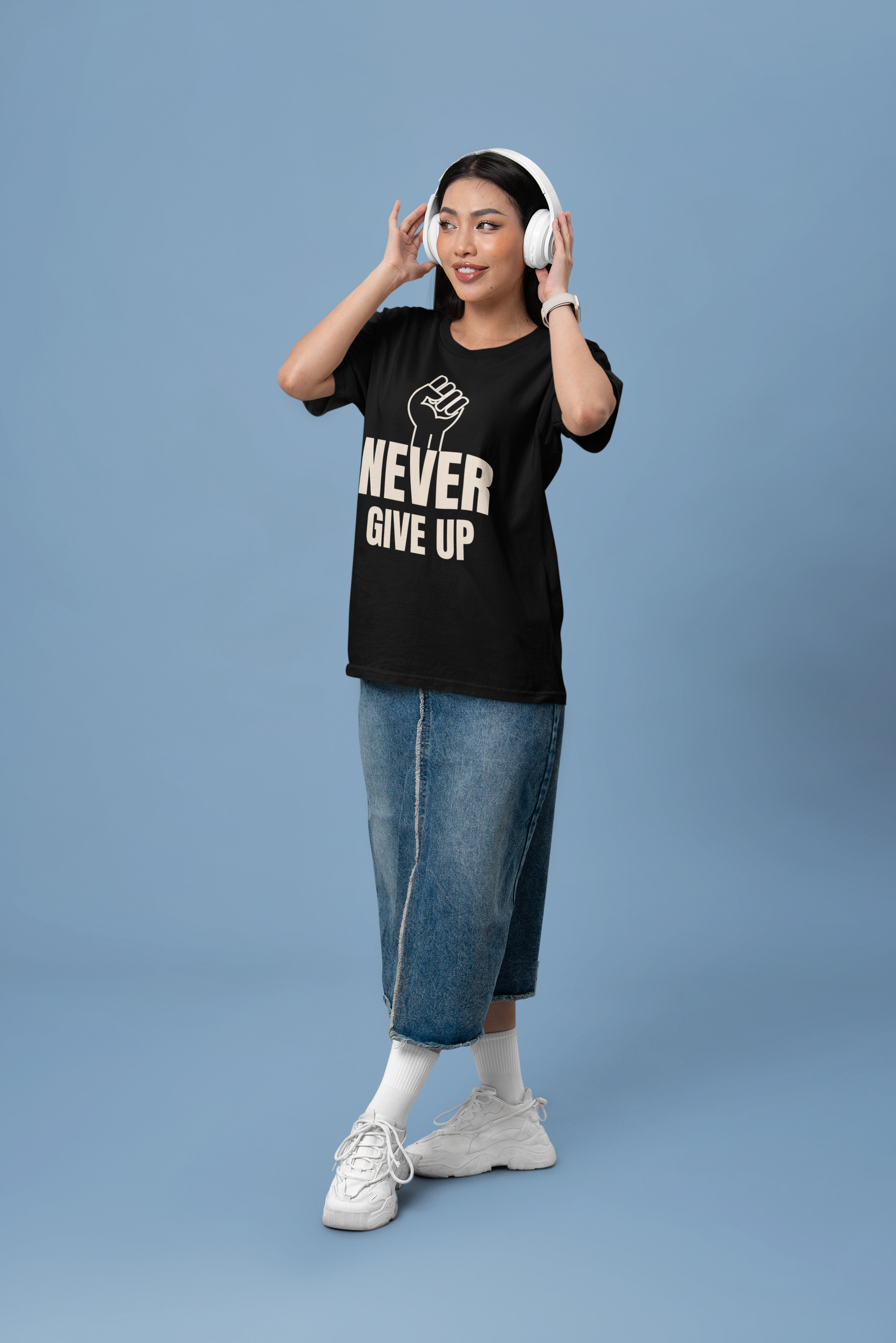Woman wearing a motivational t-shirt that says 'NEVER GIVE UP' with a fist graphic, showcasing resilience.