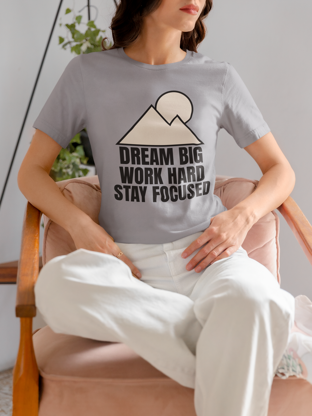 Woman wearing Mountain Minimalist T-Shirt with mountain and sun graphic, promoting a message of focus and determination.