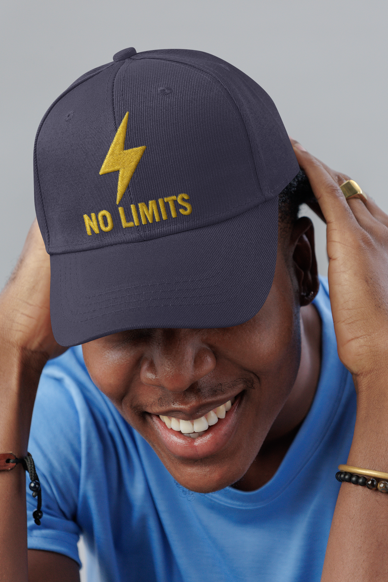No Limits Embroidered Dad Hat – Black cap with bold lightning embroidery worn by smiling man in blue shirt.