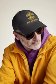 Embroidered Dad Hat Stay Grounded – Black motivational cap with yellow embroidery worn by man in yellow jacket.