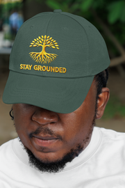 Embroidered Dad Hat Stay Grounded – Green embroidered cap with motivational quote worn by man outdoors.