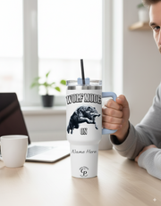 Man holding a Personalized Tumbler Wolf Mode at a desk with laptop, showcasing motivational wolf design and custom name option.