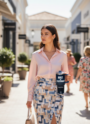 Woman walking confidently outdoors holding a Personalized Tumbler Built By Yesterday in her hand, stylish streetwear fashion.